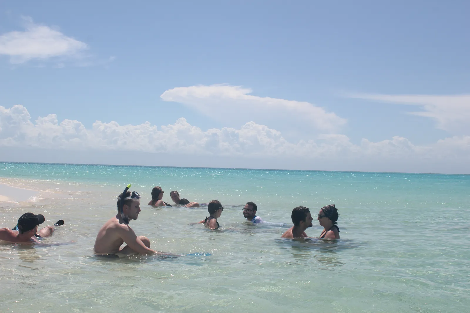 Groupe de voyageurs en masque et tuba dans une eau peu profonde à Zanzibar