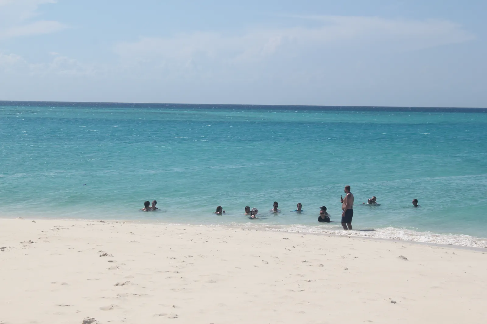 Baignade dans une eau turquoise sur un banc de sable à Zanzibar