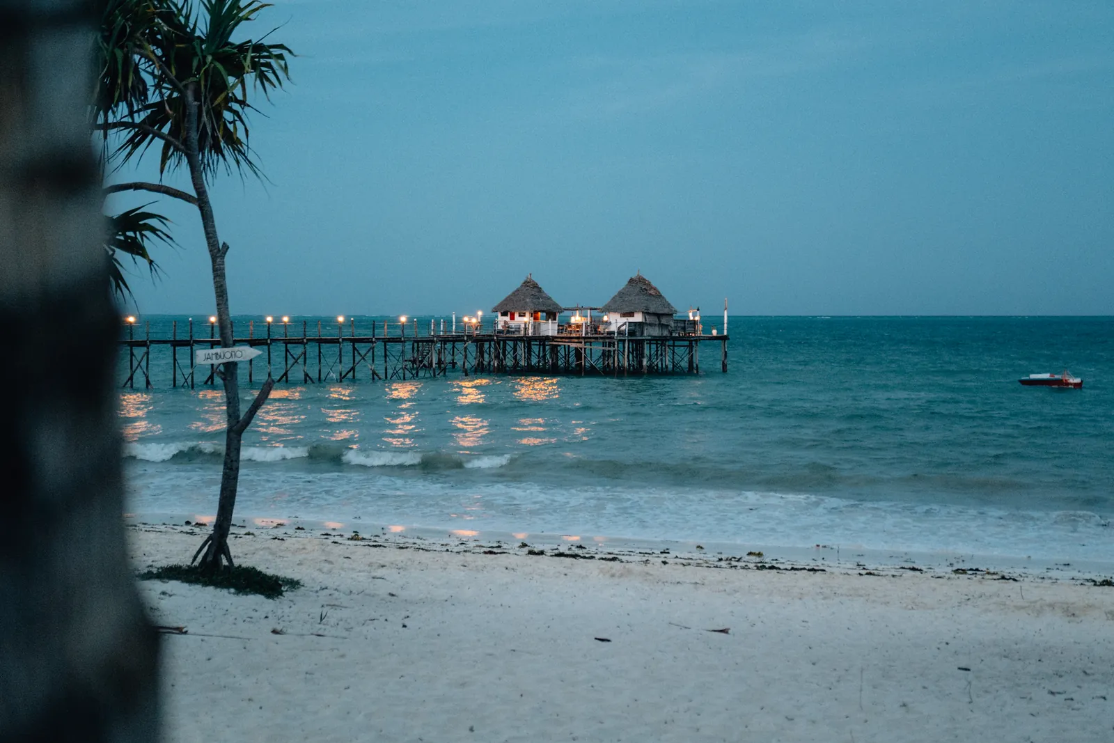 Ponton en bois et paillotes au crépuscule sur une plage de Zanzibar